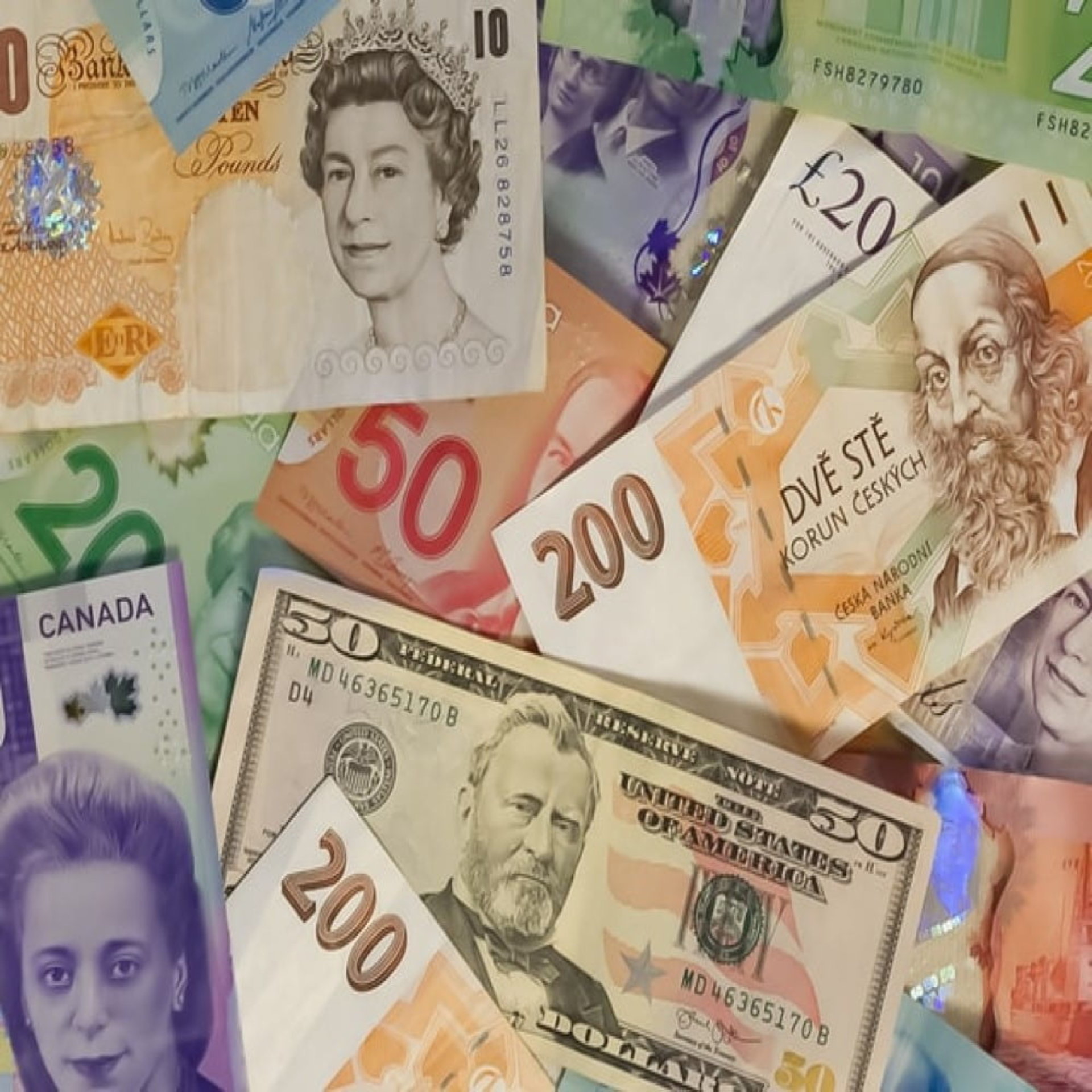 pile of colorful cash money bills of various demoninations and countries